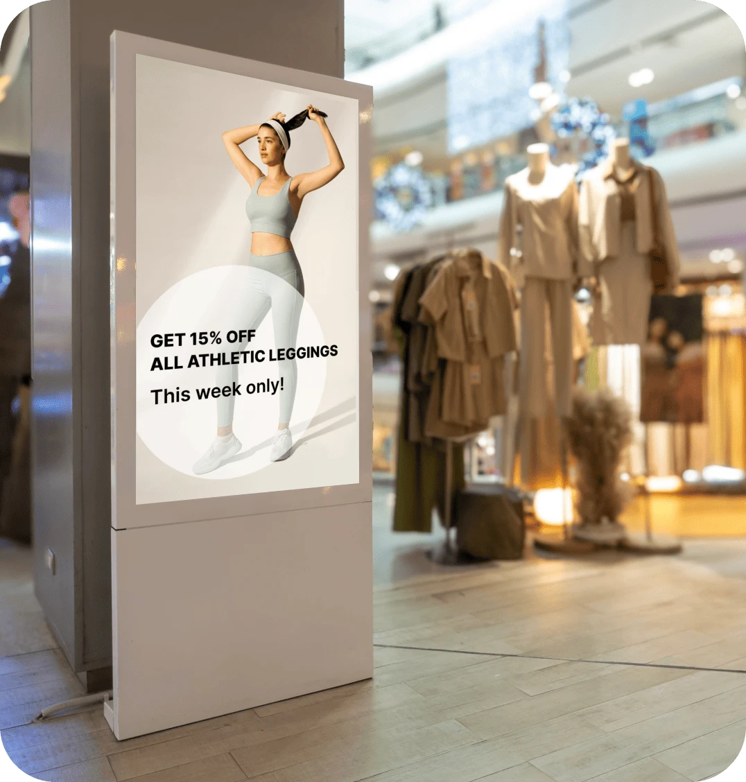 A digital signage display in a retail store displays an ad for discounted leggings