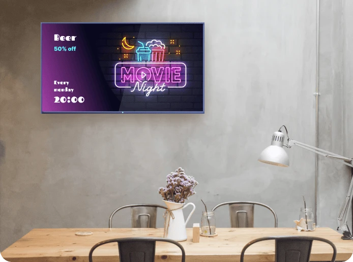 A digital signage display shows a slide with a promotion for an upcoming movie night at the quick service restaurant