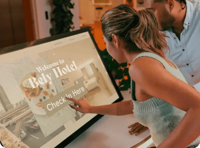 A woman uses an interactive touch screen to check into a hotel