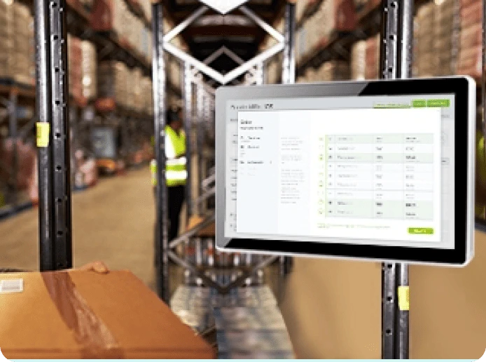 A tablet is mounted on a shelf in a warehouse and displays operational data.