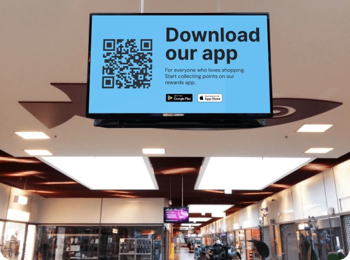 A retail digital display shows a QR code with a link to a store's rewards app