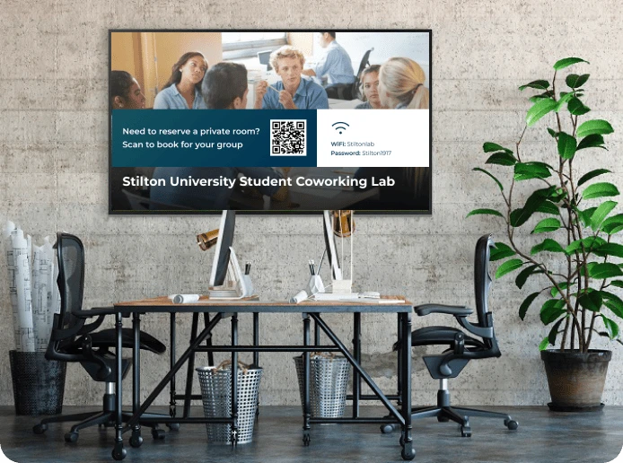 A digital signage screen in a university computer library displays a QR code with wifi details